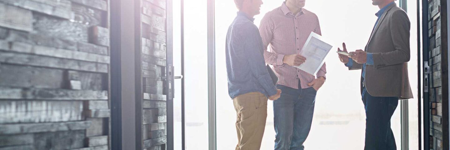 three engineers chatting in a hallway