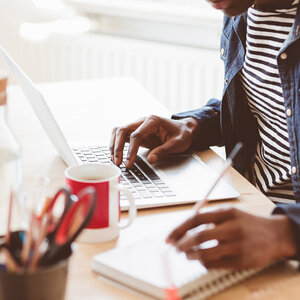 Writer in a striped shirt sitting at a desk