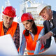 three construction professionals reviewing blueprints